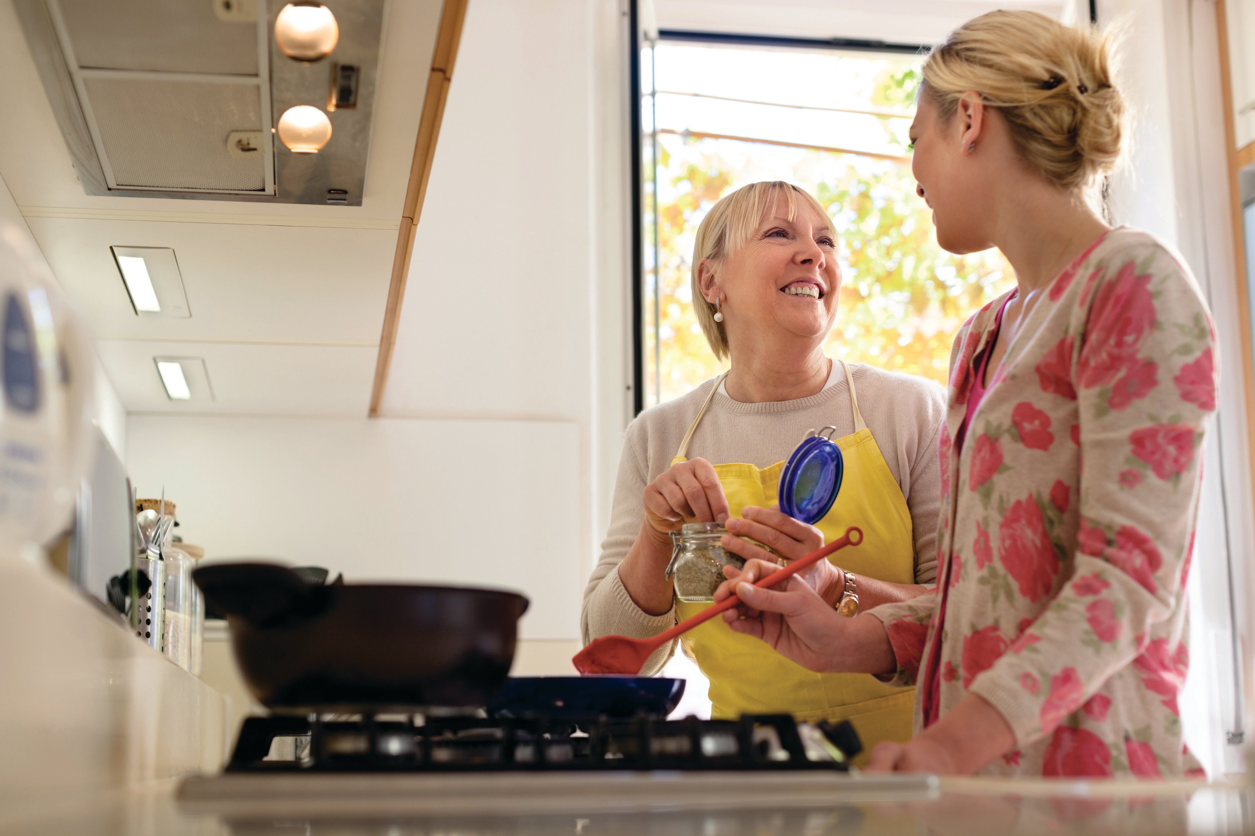 Two women talking while cooking a meal.